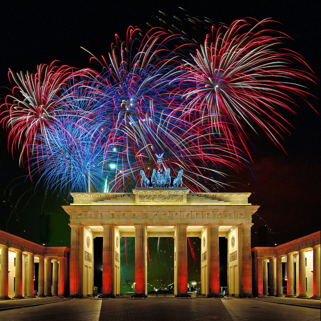 Colorful fireworks bursting over the illuminated Brandenburg Gate at night