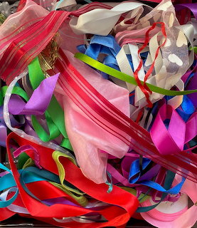 Pile of colorful ribbons in various textures including satin and organza in pink, blue, green, and red