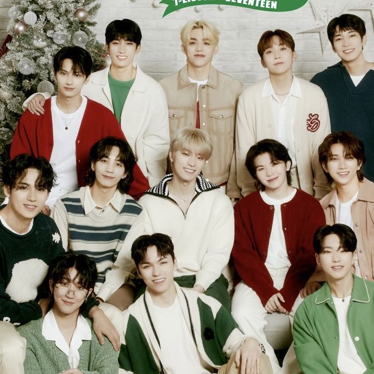 Eleven young men posing indoors in festive outfits beside a decorated Christmas tree