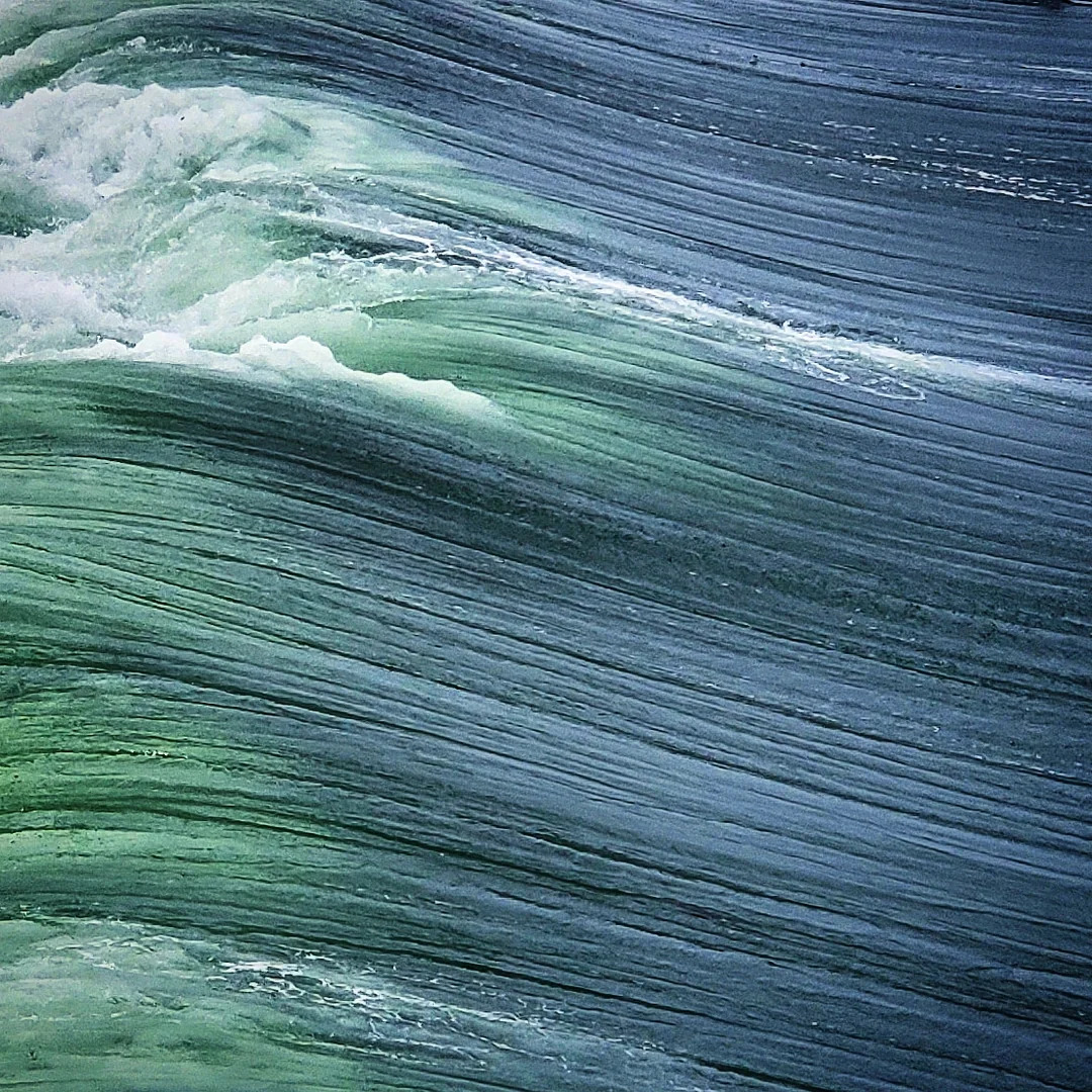 Close-up of ocean waves showing blue and green water with white foam