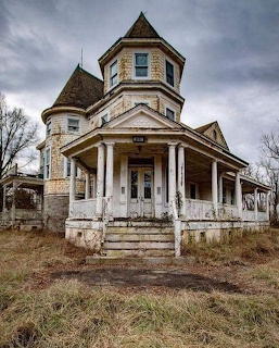 Abandoned Victorian house with turret and wrap-around porch under cloudy sky