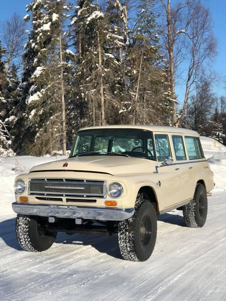 Vintage off-road SUV on a snowy forest road under a blue sky
