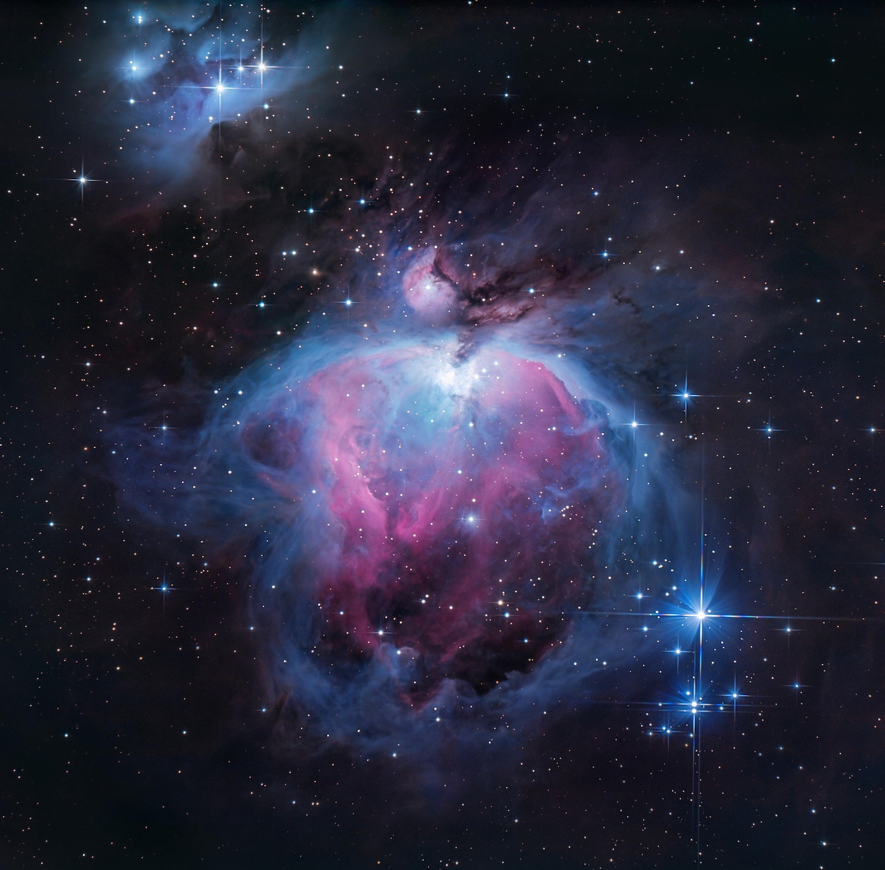 Colorful Orion Nebula with pink and blue gas clouds and bright stars in deep space