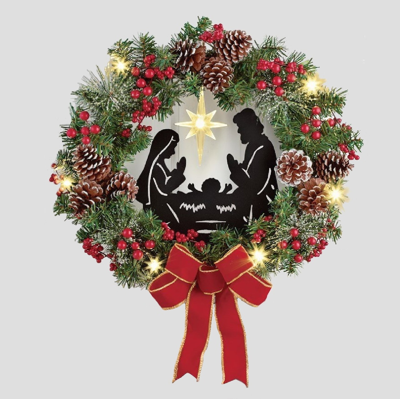 Christmas wreath with nativity silhouette, pine branches, berries, pinecones, lights, and red bow