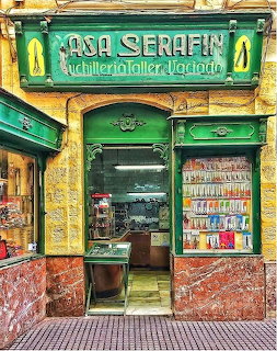 Vintage Spanish shop entrance with green Casa Serafin sign, yellow walls, and colorful decorative tiles