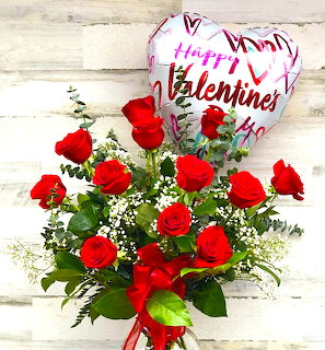 Red rose bouquet with Valentine's Day balloon on white wood background