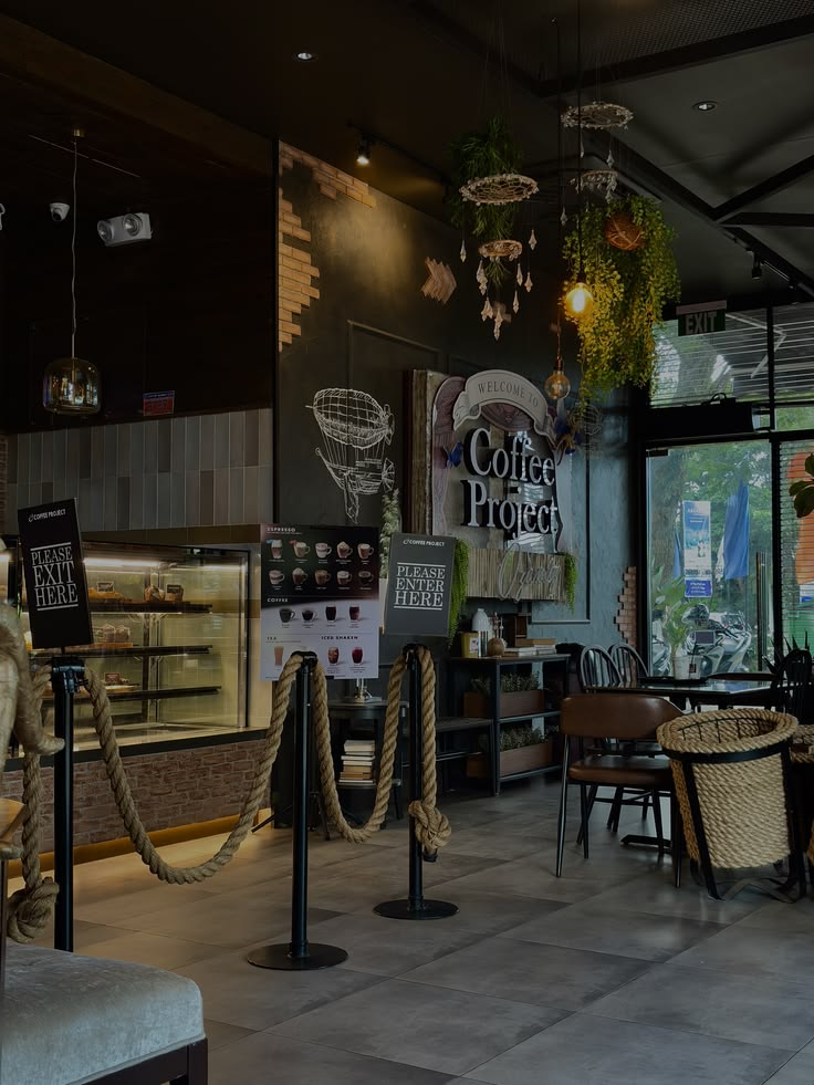 Dark moody cafe interior with pendant lights, chalkboard wall art, and rope barrier