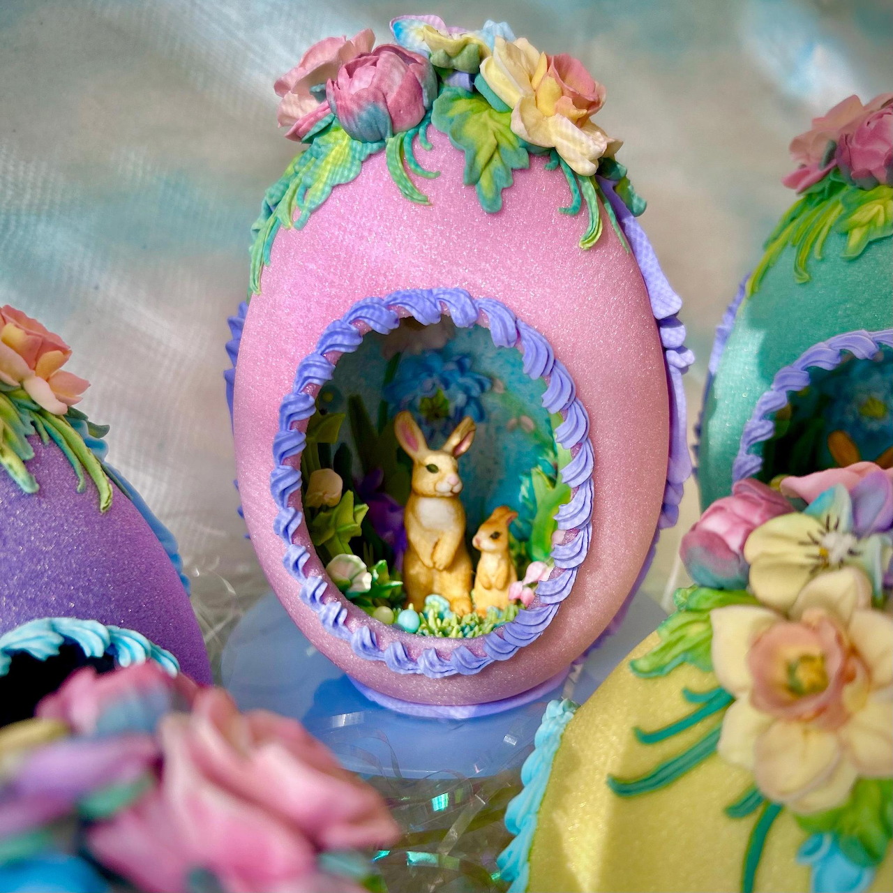 Pink sugar egg with floral icing decoration and window showing bunny figurine