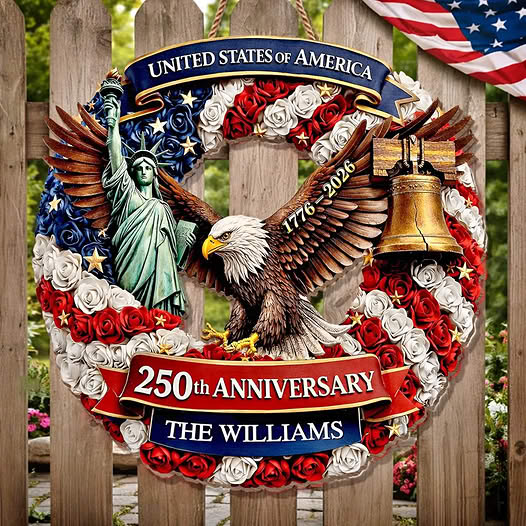 Patriotic wreath with eagle, Statue of Liberty, Liberty Bell, roses, and American flags on a fence