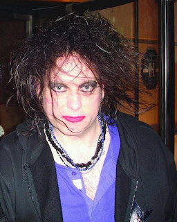 Robert Smith of The Cure with wild dark hair and red lipstick