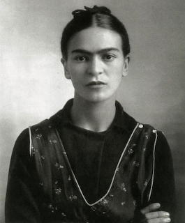Black and white portrait of Frida Kahlo in traditional embroidered dress, 1932