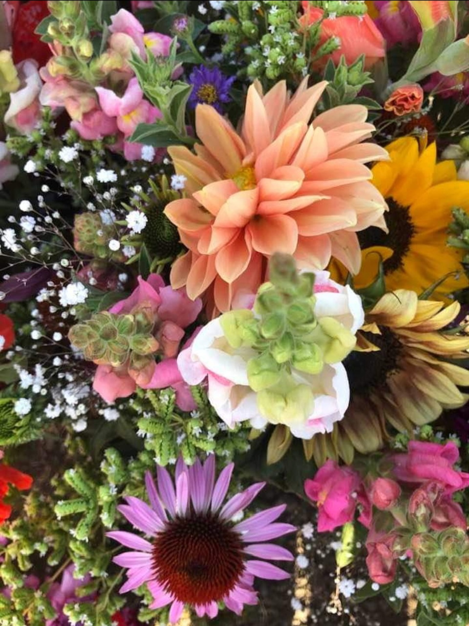 Close-up of a colorful mixed flower bouquet with peach, pink, yellow, and purple blossoms