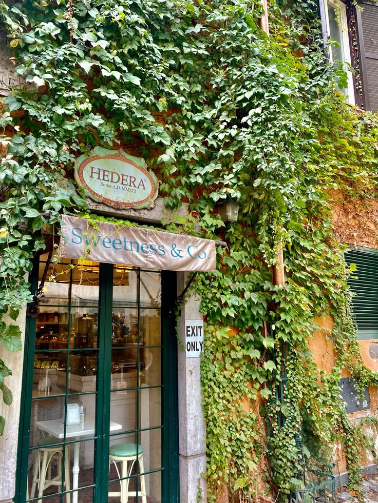 Quaint café storefront in Rome with outdoor tables and greenery