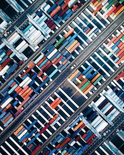Aerial drone photo of colorful shipping containers and railway tracks at a port terminal