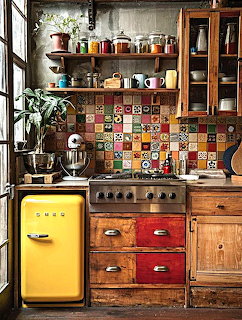 Vintage kitchen with yellow retro refrigerator, colorful tile backsplash, wooden cabinets, and open shelving