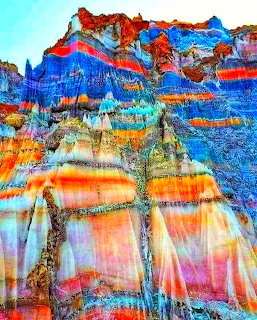 Colorful layered rock salt formations with blue, orange and red horizontal bands in Zagros Mountains
