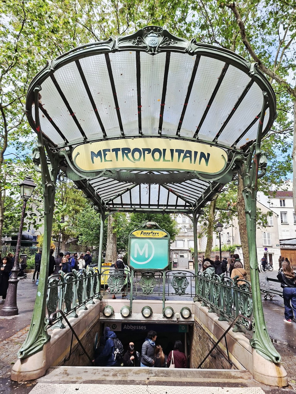 Art Nouveau metro entrance with Metropolitain sign and stairway under trees
