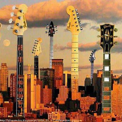 Multiple guitar necks towering over a city skyline bathed in warm golden sunset light