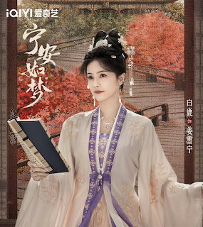 Woman in traditional Chinese hanfu holding a book indoors with autumn foliage behind her