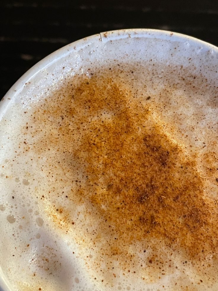 Close-up of cappuccino foam sprinkled with cinnamon powder