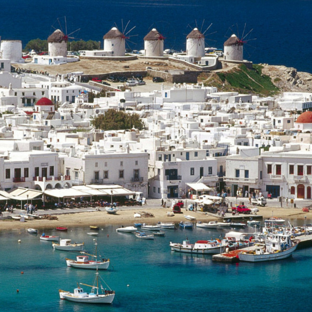 White buildings, boats, and hilltop windmills in Mykonos, Greece