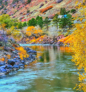 River winding through colorful autumn canyon with orange and yellow trees along rocky banks
