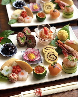 Assorted Japanese appetizers beautifully arranged on white rectangular plates with chopsticks