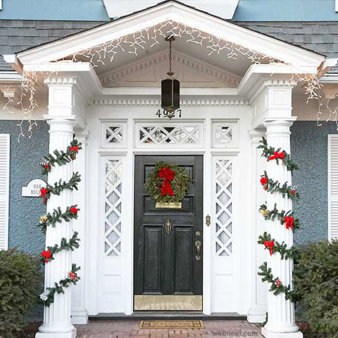 Christmas decorated front door with wreath and garland on white columned entrance