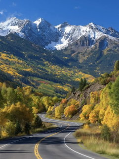 Scenic mountain highway with fall colors and snowy peaks in Colorado