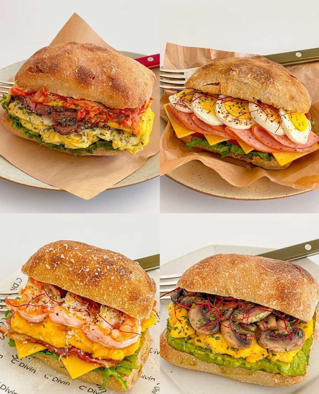 Four breakfast sandwiches with eggs, cheese, meat and vegetables on seeded rolls