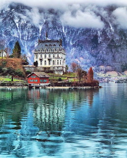 White castle on Lake Brienz with snowy mountains and turquoise water