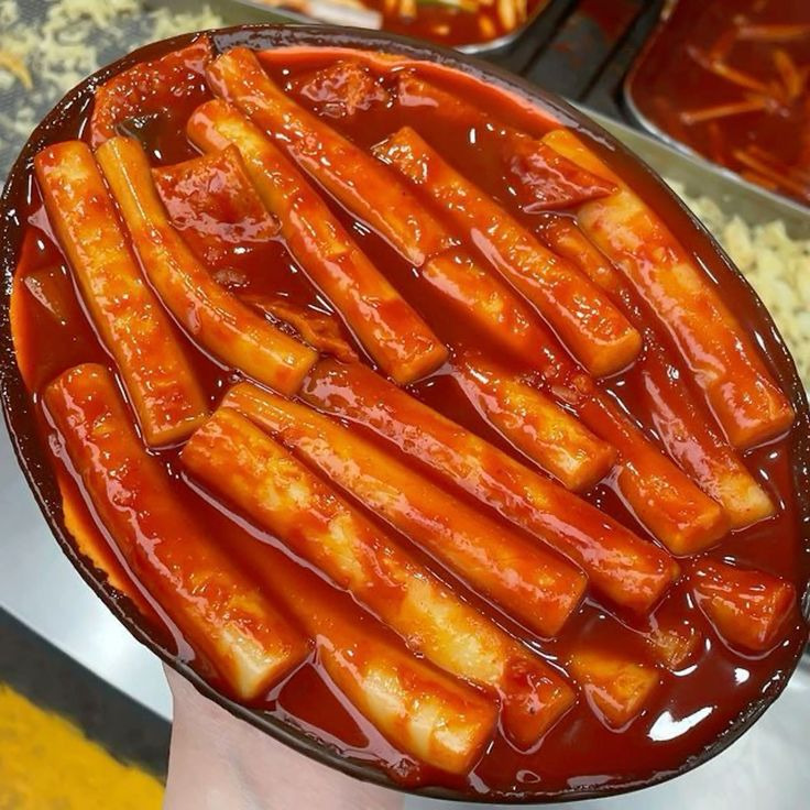 Bowl of glossy tteokbokki rice cakes in red spicy sauce