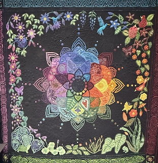 Colorful handmade show quilt with detailed patchwork and intricate stitching