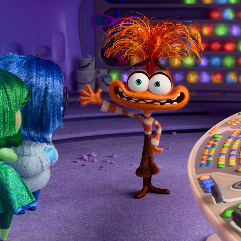 Orange-haired animated character with googly eyes from Inside Out movie in control room setting
