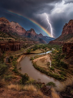 Desert canyon with river, lightning bolt, and rainbow under storm clouds