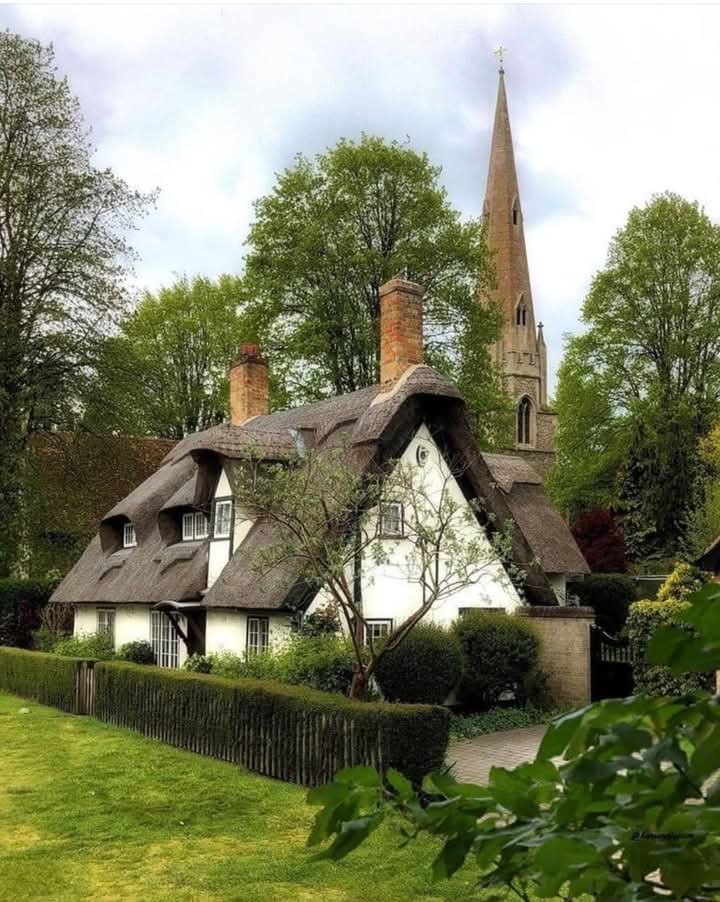 Quaint cottage house with garden and flowers in a rural landscape