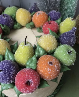 Cake decorated with colorful sugar-coated candied fruit shapes in yellow, orange, pink, purple, and green