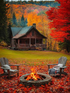 Log cabin with campfire and chairs amid colorful autumn trees