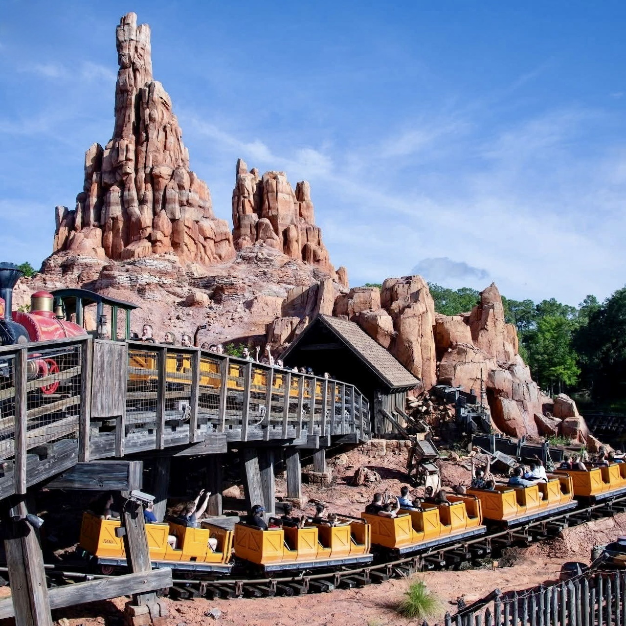 Big Thunder Mountain Railroad roller coaster with yellow trains navigating through sculpted red rock mountains