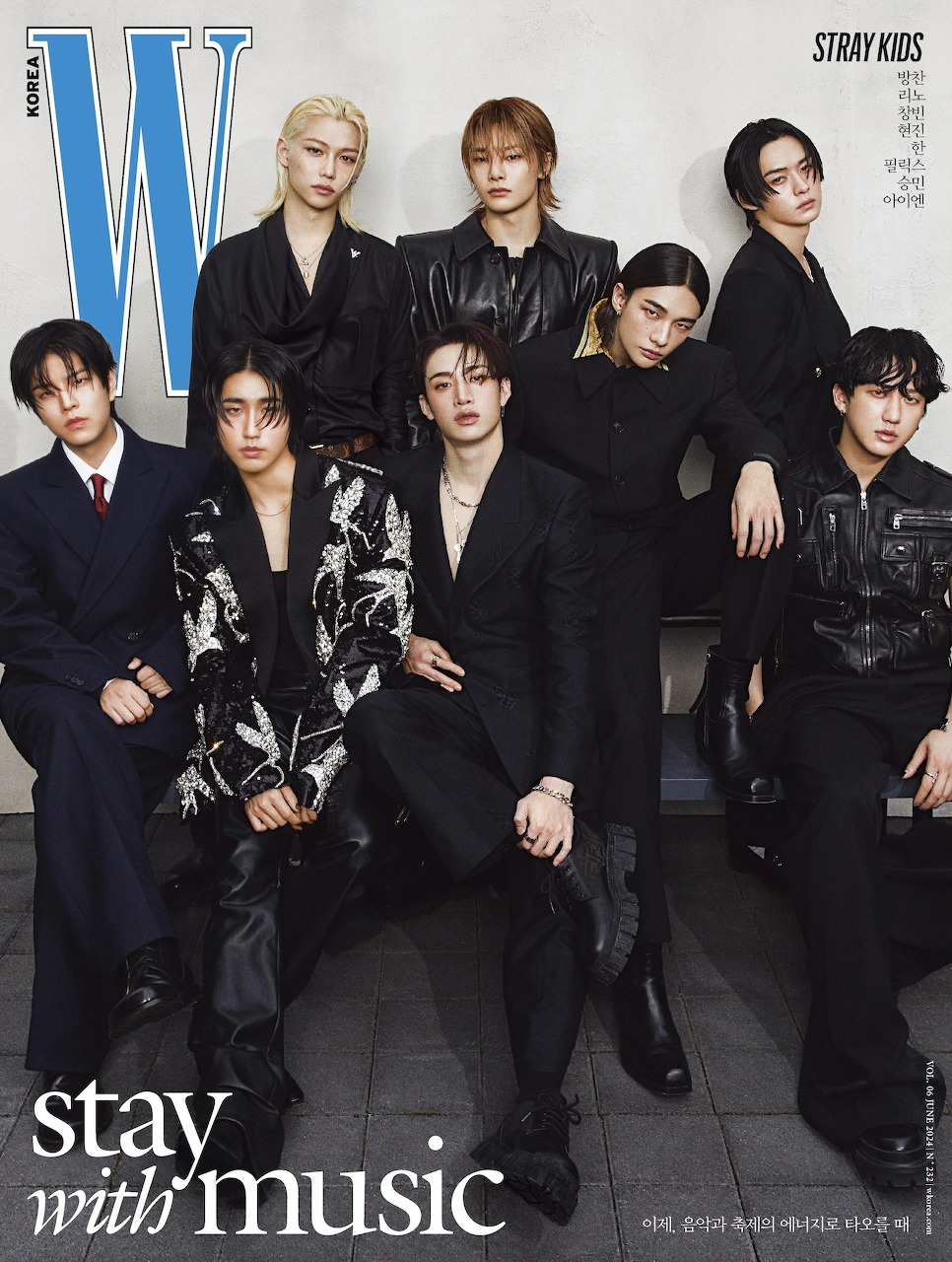 Stray Kids members posing on W Korea magazine cover with 'stay with music' text