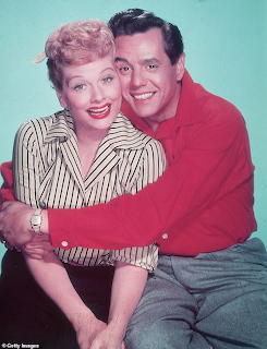 Lucille Ball and Desi Arnaz smiling in a vintage studio portrait