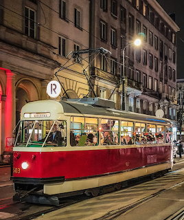 Red and cream vintage tram number 503 on a Brussels street at night with lit buildings
