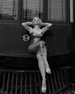 Woman in sequined dress sitting on steps in black and white photo