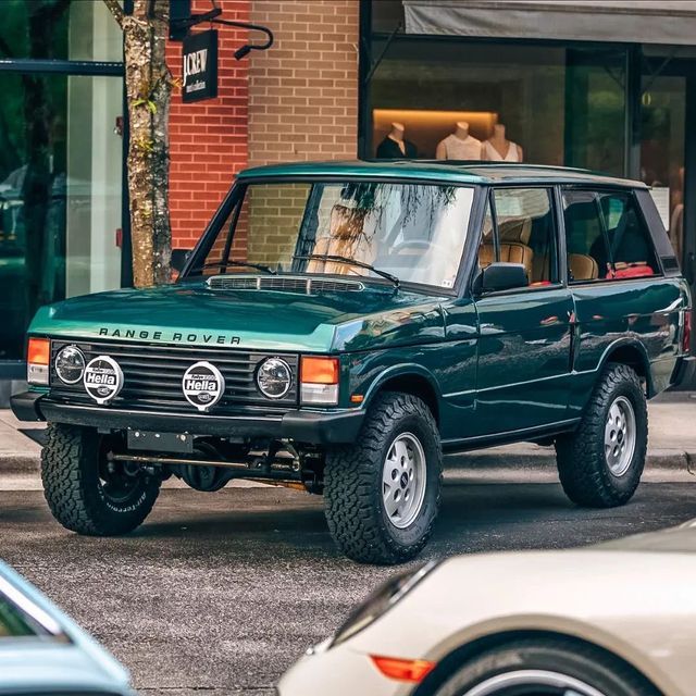 Dark green classic Range Rover SUV parked on a city street