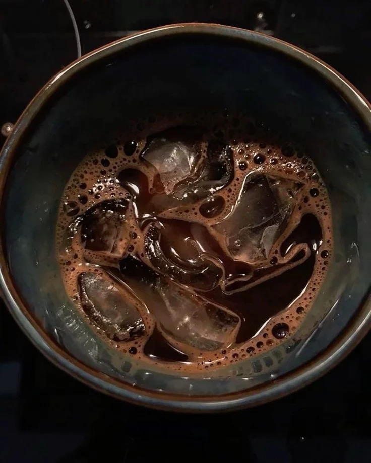 Glass of iced coffee with espresso poured over ice cubes and milk