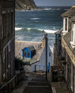 Narrow lane between houses leading down to the sea in Gardenstown, Scotland