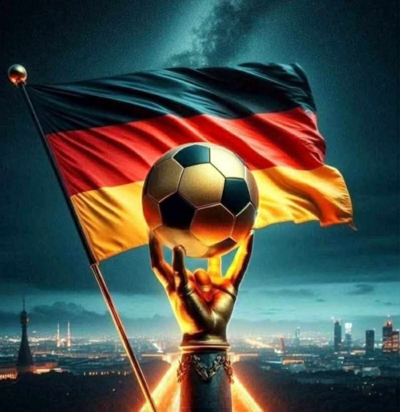 Golden soccer trophy with a football and German flag above a city at night