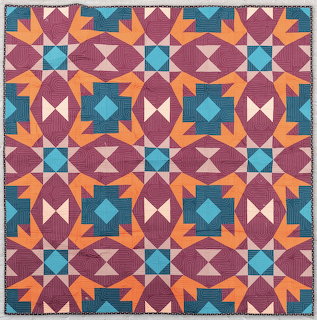Geometric quilt with burgundy, teal, orange star blocks in repeating pattern