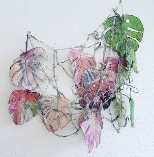 Botanical illustration of pink and green tropical leaves with thin trailing vines on white