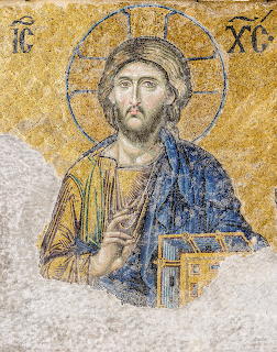 Byzantine mosaic of Christ Pantocrator with halo and gospel book on gold background